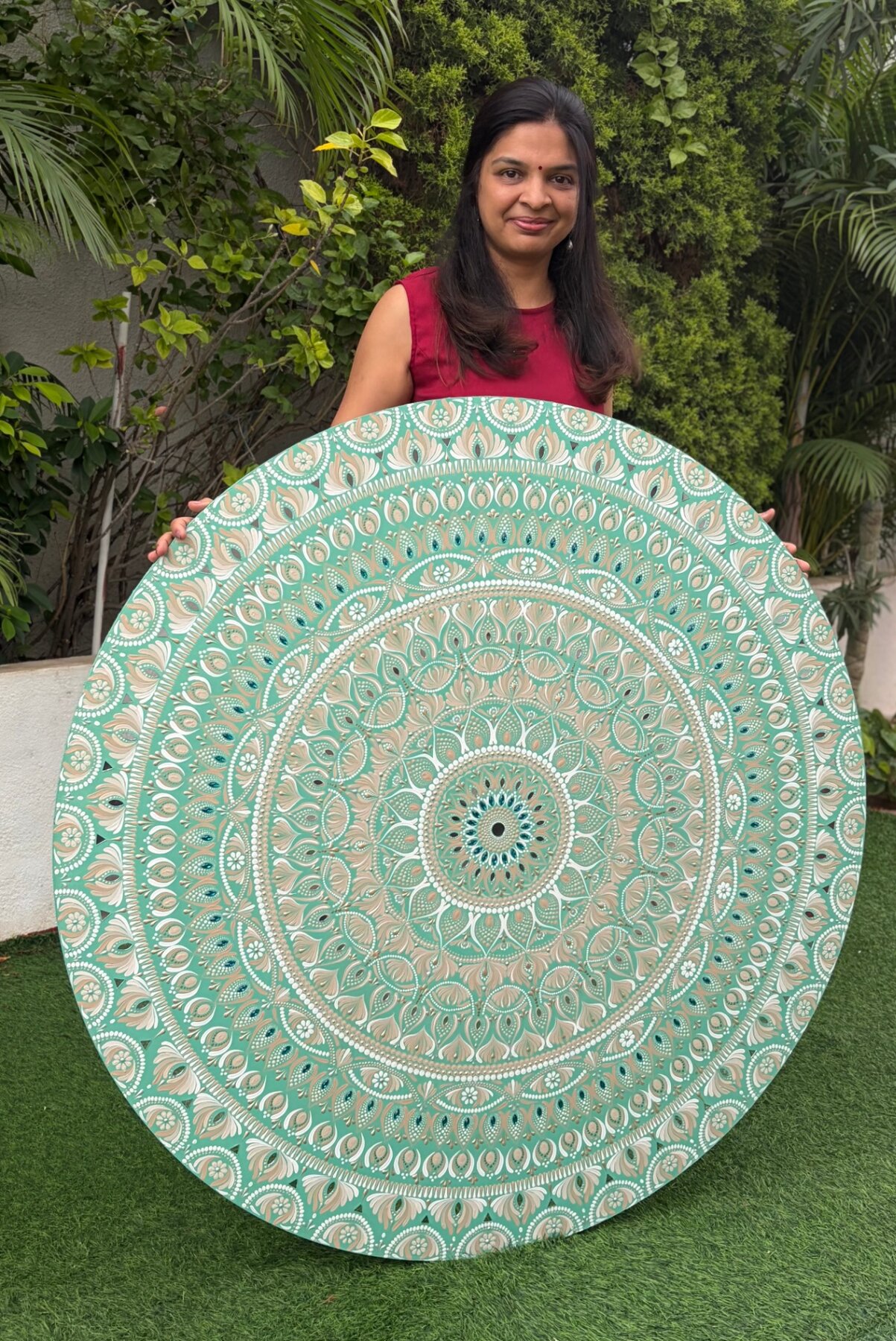 Nandhini holding a large commissioned mandala